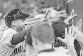  ?? John Bazemore / Associated Press ?? George Springer celebrates another busy night at the plate and on the bases for the Astros, who followed a 19-hit game Tuesday with 16 more hits Wednesday.