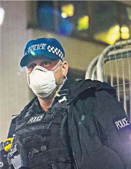  ??  ?? A police officer wears a face mask as he stands guard outside St Thomas’ Hospital in central London, where Prime Minister Boris Johnson, who has contracted Covid-19, has been admitted