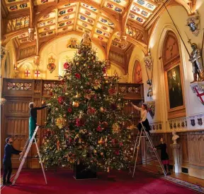  ?? ?? Rocking around: Staff decorate the 20ft-tall tree in St George’s Hall