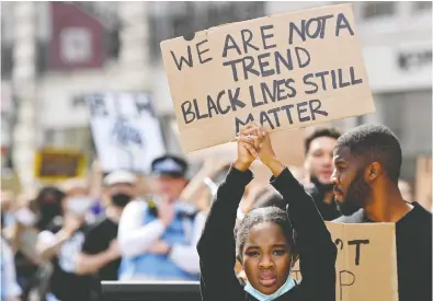  ?? TOBY MELVILLE / REUTERS ?? A protester holds up a sign on Sunday during a Black Lives Matter march in London, Britain.