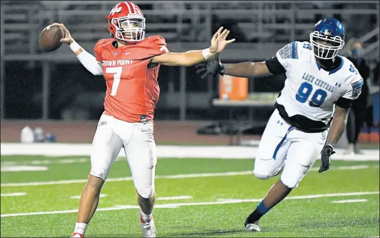  ?? KYLE TELECHAN / POST-TRIBUNE ?? Crown Point QB Will Pettit, left, the son of former coach Chip Pettit, passes while being pressured by Lake Central’s Armond Earving .