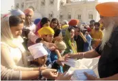  ?? — PRITAM BANDYOPADH­YAY ?? Masks being distribute­d for free at Gurdwara Bangla Sahib in New Delhi on Sunday.