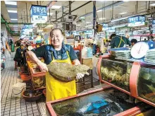  ?? Korea Times Photo by Shim Hyun-chul ?? A fishmonger poses with a live fish in Jagalchi Fish Market in Busan’s Jung District, March 31, 2023.