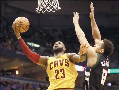  ?? (AP FOTO) ?? OPEN LANE. LeBron James gets an easy look at the basket against Malcom Brogdon of Milwaukee. James scored 34 points, including the go-ahead three-pointer in overtime in Cleveland’s 20th win of the season.