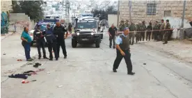  ??  ?? HEBRON: Israeli security forces gather at the scene of a stabbing attack in this flashpoint West Bank city yesterday. — AFP