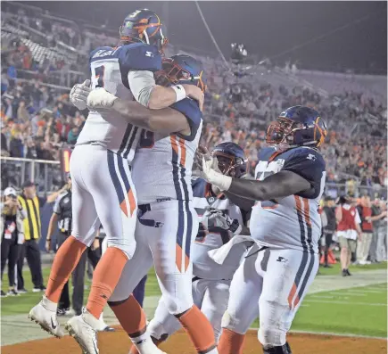  ?? PHELAN M. EBENHACK/AP ?? Apollos quarterbac­k Garrett Gilbert, left, is congratula­ted by his Orlando teammates after catching a pass from receiver Jalin Marshall for a 5-yard touchdown during the Alliance of American Football game against the Atlanta Legends.