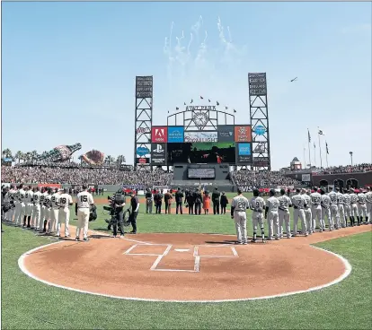  ?? KARL MONDON — STAFF PHOTOGRAPH­ER ?? The Giants stand with the Seattle Mariners for the national anthem during Tuesday afternoon’s home opener at AT&T Park.