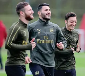  ??  ?? All smiles: Ozil with Mustafi (left) and Kolasinac yesterday