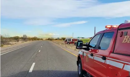  ?? Photograph: Tucson Fire Service/Reuters ?? Emergency vehicles are seen as an overturned truck spews orange smoke in the background at I-10 Highway in Tucson, Arizona.