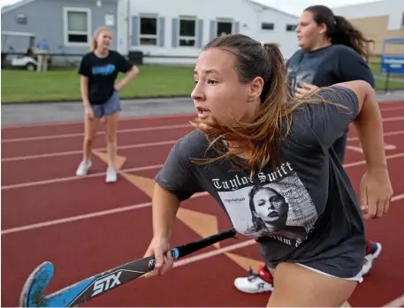  ?? MATT sTonE pHoTos / HErAld sTAFF ?? MAJOR MOMENT: Southeaste­rn field hockey player Erin Tripp runs on the track during practice on Friday in South Easton. Below, the team holds their sticks up high during practice.