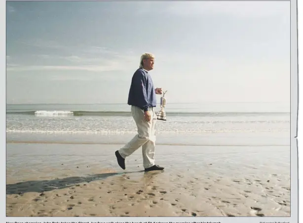  ?? Picture:ian Rutherford ?? New Open champion John Daly takes the Claret Jug for a walk along the beach at St Andrews the morning after his triumph