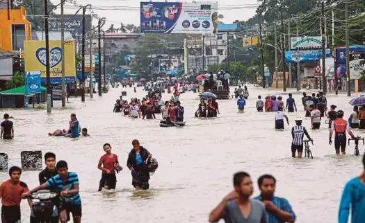  ?? EPA PIC ?? Residents wading through a flooded YangonMand­alay road in Bago region, Myanmar, on Saturday.