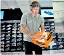  ??  ?? CANADA: An employee of Sports Experts disinfects a shoe box, May 25