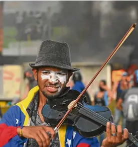  ?? AFP ?? VIOLIN MAN Violinist Wuilly Arteaga plays the classic Venezuelan folk song “Alma Llanera” as a peace message.—