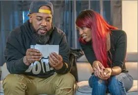  ?? Christian Snyder/Post-Gazette ?? Tameka Dallas’ brother, Brandon, and daughter Talasia look over family photos while discussing Tameka on Saturday in Pitcairn.