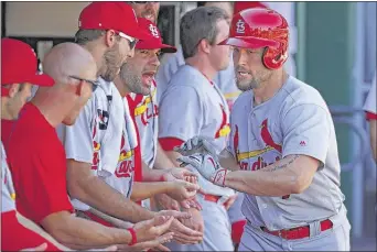  ?? GENE PUSKAR/ASSOCIATED PRESS ?? Matt Holliday (right) celebrates with Cardinals teammates after hitting a solo home run off Pirates starting pitcher Jonathon Niese in the first inning in Pittsburgh. It was one of three hits for the St. Louis slugger on Sunday.