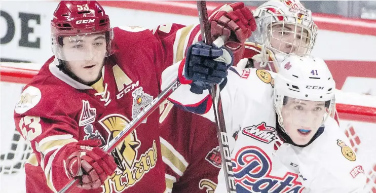  ??  ?? Regina Pats’ Cameron Hebig fights for the puck with Acadie-Bathurst Titan’s Noah Dobson during first period Memorial Cup action in Regina on Sunday. — THE CANADIAN PRESS