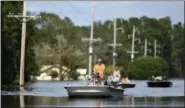  ?? MATT BORN — THE STAR-NEWS VIA AP ?? Area residents ride down N.C. Highway 53 that is flooded from the Northeast Cape Fear River in Burgaw, N.C., Wednesday. The river had severe flooding due to the rains from Hurricane Florence.