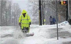  ??  ?? CARRBORO, North Carolina: A city worker removes snow from a crosswalk as a winter storm blankets the area on Jan 7, 2017. — AP