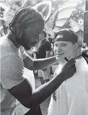  ?? WORLD RED EYE ?? UM cornerback Al Blades signs the T-shirt of a patron at Pilo’s Tequila Garden in Wynwood on Monday during an NIL appearance by him and some other teammates, including D’Eriq King and Ryan Ragone. Under the guidance of attorney Adam Arnaout, they met and mingled with people with special needs who are supported in their efforts by the restaurant.