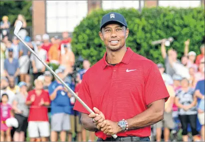  ??  ?? Tiger Woods holds Calamity Jane the official trophy of the tournament after winning the Tour Championsh­ip golf tournament Sunday, in Atlanta.