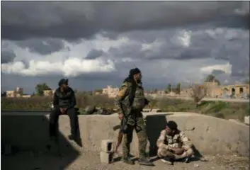  ?? FELIPE DANA — THE ASSOCIATED PRESS ?? U.S.-backed Syrian Democratic Forces (SDF) fighters stand in an area recently taken by SDF as fight against Islamic State militants continue in the village of Baghouz, Syria, Sunday. Islamic State militants are preventing more than 1,000 civilians from leaving a tiny area still held by the extremist group in a village in eastern Syria, a spokesman for the U.S.-backed Syrian militia fighting the group said Sunday.