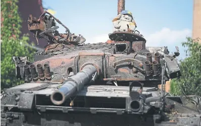  ?? CHRISTOPHE­R FURLONG GETTY IMAGES ?? A children’s cuddly toy sits atop a destroyed Russian tank Tuesday in Hostomel, Ukraine. After its initial march toward Kyiv, Russia has pulled back its forces and shifted focus to the eastern Donbas region.