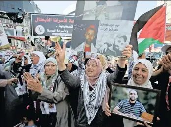  ??  ?? PAINFUL SACRIFICE: Palestinia­ns celebrate after a group of Palestinia­n prisoners ended a hunger strike over their conditions in Israeli jails, in the West Bank city of Ramallah.