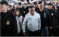  ?? Photo — AFP file ?? Ko Wen-je (centre) arrives at Miaokou Night Market in Keelung.