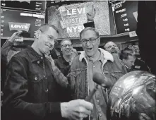  ?? [RICHARD DREW/THE ASSOCIATED PRESS] ?? Levi Strauss CEO Charles Bergh, left, rings a ceremonial bell to celebrate his company beginning to trade on the New York Stock Exchange on Thursday. The NYSE suspended its “no jeans” rule in honor of Levi’s second IPO.