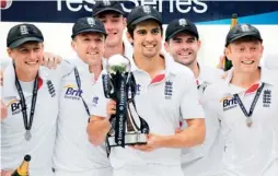 ??  ?? England’s Alastair Cook, center, holds the trophy with teammates as England celebrates a series win on the fifth day in the second internatio­nal cricket Test match between England and New Zealand at Headingly in Leeds on Tuesday. (AFP)