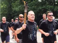  ?? Ned Gerard / Hearst Connecticu­t Media file photo ?? Trumbull Police Chief Michael Lombardo carries the torch in the Law Enforcemen­t Torch Run for Special Olympics seen here in Trumbull on June 8, 2018. The Trumbull department has received Tier 1 accreditat­ion.