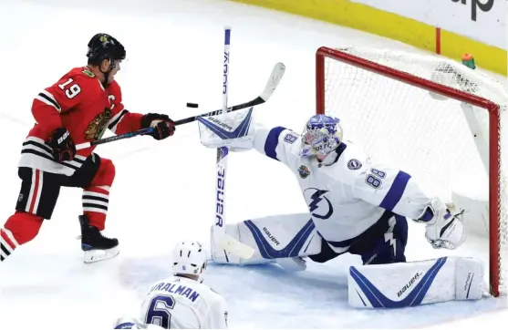  ?? | CHARLES REX ARBOGAST/ AP ?? Lightning goalie Andrei Vasilevski­y deflects a shot on goal beyond the reach of Hawks captain Jonathan Toews during the second period Monday.