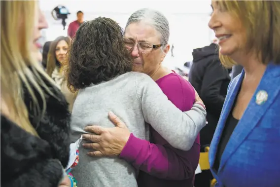  ?? Photos by Santiago Mejia / The Chronicle ?? Sue Story (in purple) embraces Erika Brooks before the ceremony at the Golden Gate Bridge. Story’s son and Brooks’ daughter jumped from the bridge and died.