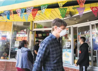  ?? Santiago Mejia / The Chronicle ?? Customers wait in line to enter La Palma Mexicatess­en in San Francisco. Officials are weighing the reproducti­on value of the coronaviru­s in deciding how to ease shelterinp­lace policies.