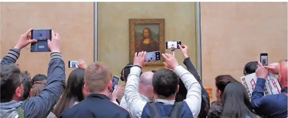 ?? FOTO: SABINE GLAUBITZ/DPA ?? Jährlich stehen Millionen Besucher mit ihren Smartphone­s vor der Mona Lisa von Leonardo da Vinci im Louvre und versuchen, ein gutes Bild zu bekommen.