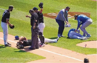  ?? CHARLES REX ARBOGAST/ASSOCIATED PRESS ?? Teammates, a trainer and an umpire check on the Chicago White Sox’s Jose Abreu, left, and Kansas City’s Hunter Dozier after the two collided along the first-baseline of Friday’s game in Chicago.