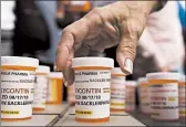  ?? JESSICA HILL/AP ?? Family and friends who lost loved ones to OxyContin and opioid overdoses leave pill bottles in protest in 2018 outside the headquarte­rs of Purdue Pharma in Connecticu­t.