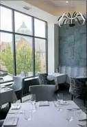  ?? Rebecca Droke/Post-Gazette ?? The dining room of the Twisted Frenchman includes Italian porcelain tile that is similar in color to the dome of the Motor Square Garden building visible through the window.