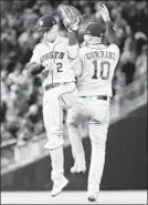  ?? ROB CARR/GETTY ?? Astros Yuli Gurriel and Alex Bregman celebrate Saturday. This year’s World Series games are averaging 3 hours, 54 minutes.