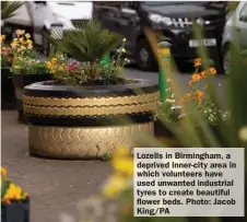  ?? ?? Lozells in Birmingham, a deprived inner-city area in which volunteers have used unwanted industrial tyres to create beautiful flower beds. Photo: Jacob King/PA