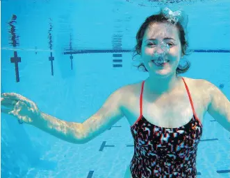  ?? LEAH HENNEL ?? Olivia Graham, pool manager at Silver Springs outdoor pool in Calgary, takes a cool dip.