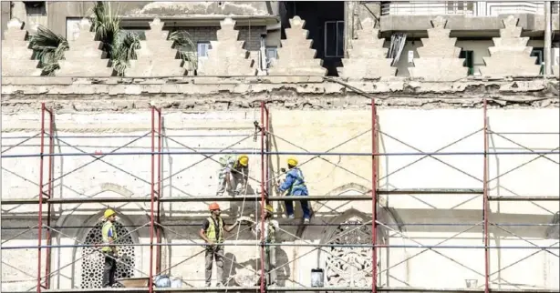  ?? KHALED DESOUKI/AFP ?? Workers stand on scaffoldin­g during renovation work on the 13th century al-Zahir Baybars mosque in Cairo on October 16.