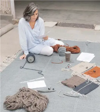 ?? POSTMEDIA FILES ?? Spanish rug designer and manufactur­er Nani Marquina checks out one of her new Mia rugs, part of an online customizab­le collection made from New Zealand wool using Indian artisans.
