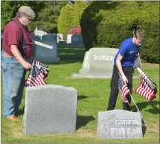  ?? PETE BANNAN - MEDIANEWS GROUP ?? Bill Jones and his grandson Gavin Borter, 14, places flags on veterans’ graves at Arlington Cemetery.