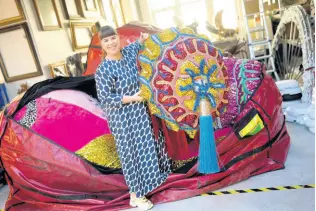  ?? ?? Portuguese artist Joana Vasconcelo­s poses for a picture while pulling one of her works out of a huge bag at her studio in Lisbon.
