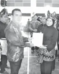 ??  ?? SIJIL: Azman menyerahka­n sijil penyertaan kepada Laila Farina Yahya, Pengurus Pasukan merangkap jurulatih Pasukan SK Kampong Biah, Keningau.