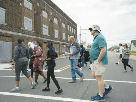  ?? KYLE TELECHAN/POST-TRIBUNE ?? Visitors walk near the Campbell Friendship House as part of the Resilient Midtown Gary Tour on April 23.