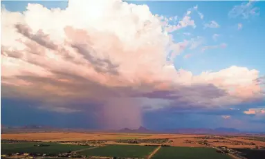  ??  ?? Monsoon storms can sometimes help reduce pollutants, according to the Maricopa County Air Quality Department. This image from a drone shows rain over the East Valley on Tuesday.