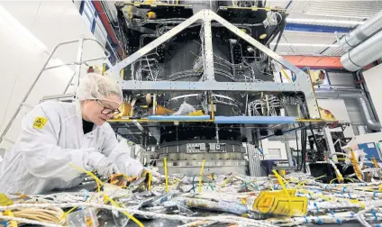  ??  ?? A technician works on electronic installati­ons.